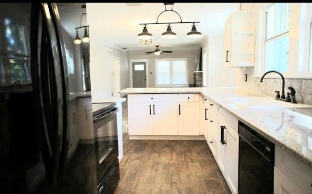 kitchen featuring pendant lighting, white cabinets, a sink, a peninsula, and black appliances