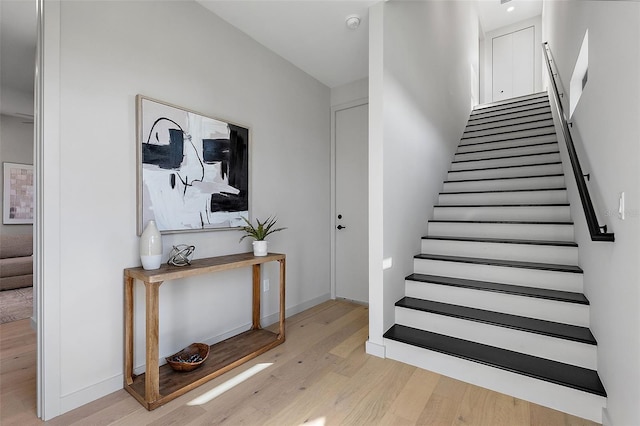 staircase with baseboards and wood finished floors