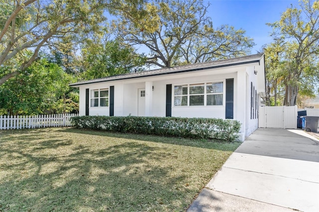 ranch-style home featuring a gate, concrete driveway, a front yard, and fence