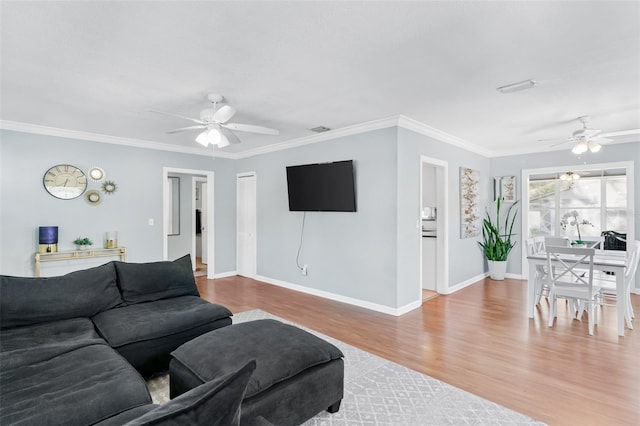 living room featuring crown molding, wood finished floors, baseboards, and ceiling fan