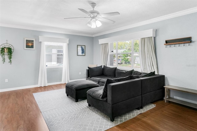 living area featuring a ceiling fan, ornamental molding, wood finished floors, and a healthy amount of sunlight