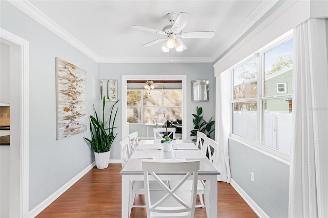 dining room featuring ornamental molding, wood finished floors, baseboards, and ceiling fan