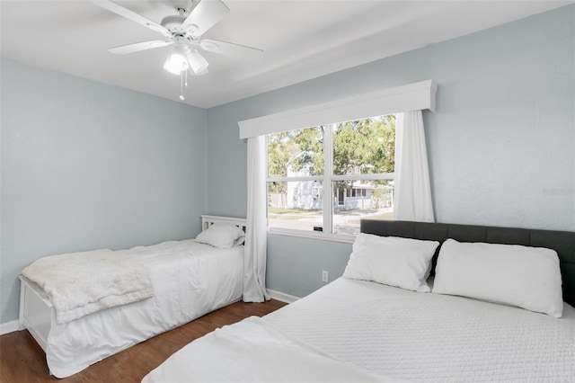 bedroom with ceiling fan, baseboards, and wood finished floors