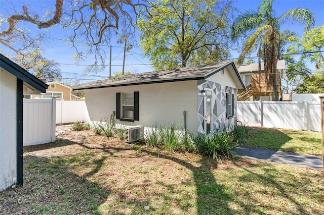 view of side of property with an outdoor structure and fence