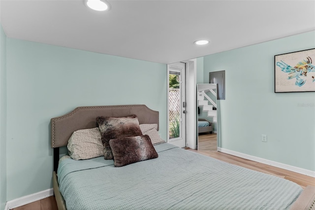 bedroom with recessed lighting, wood finished floors, and baseboards