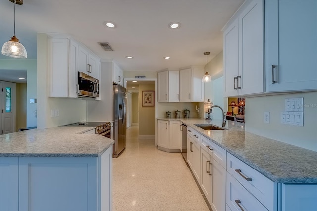 kitchen featuring visible vents, white cabinets, a peninsula, stainless steel appliances, and a sink