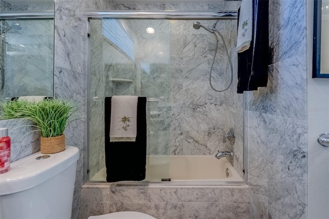 bathroom featuring tiled shower / bath combo and toilet