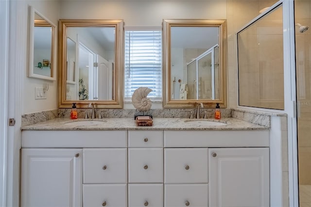 bathroom with double vanity, a stall shower, and a sink