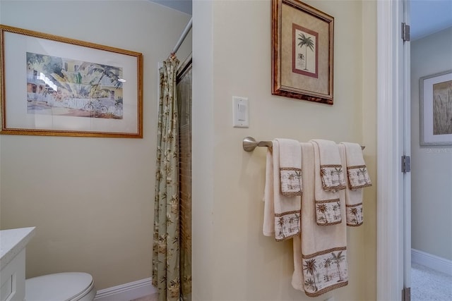 bathroom with toilet, curtained shower, vanity, and baseboards