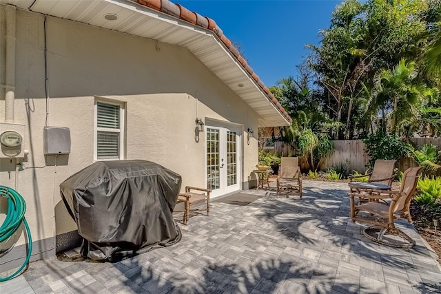 view of patio / terrace with french doors, fence, and grilling area