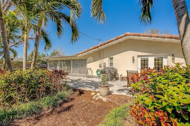 back of property featuring a patio area, fence, a tiled roof, and stucco siding