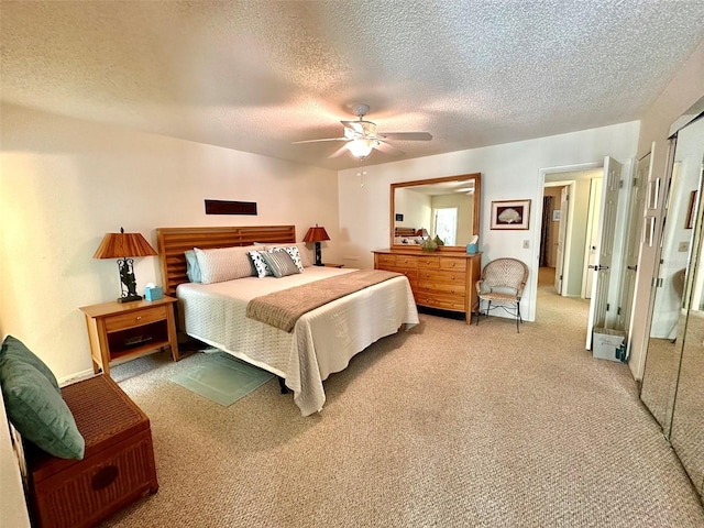 carpeted bedroom with ceiling fan and a textured ceiling