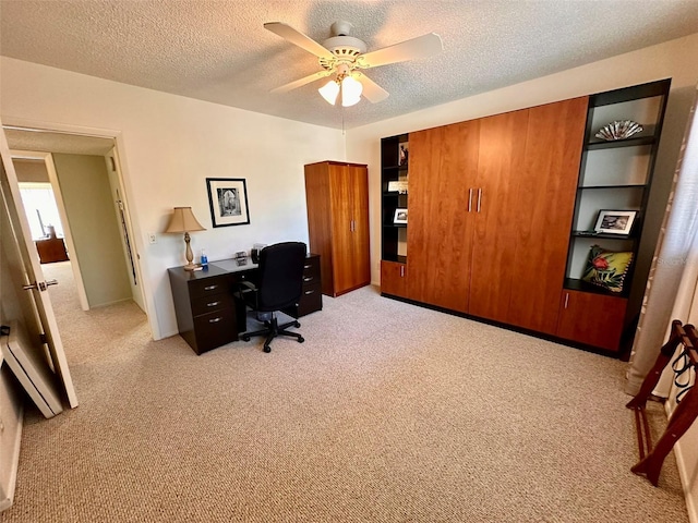 office with light carpet, a ceiling fan, and a textured ceiling