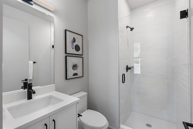 full bathroom featuring a shower stall, vanity, and toilet