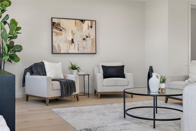 living area featuring light wood-style floors and baseboards