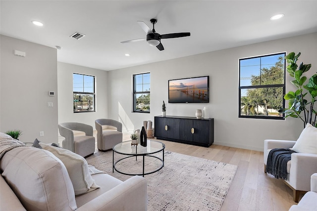 living room featuring ceiling fan, light wood-style flooring, visible vents, and recessed lighting