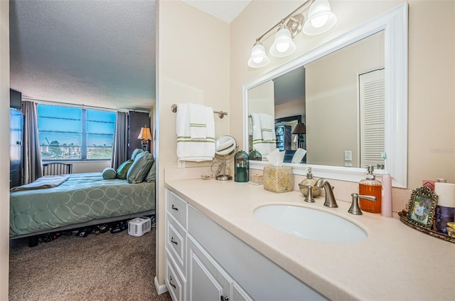 bathroom featuring ensuite bath, a textured ceiling, and vanity