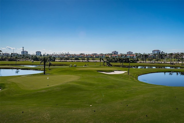 view of community with view of golf course, a water view, and a view of city