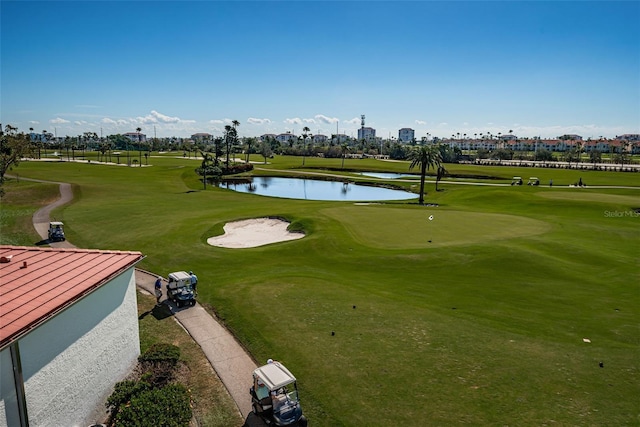 surrounding community featuring golf course view, a water view, and a lawn