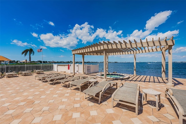 view of patio with a water view, a hot tub, fence, and a pergola