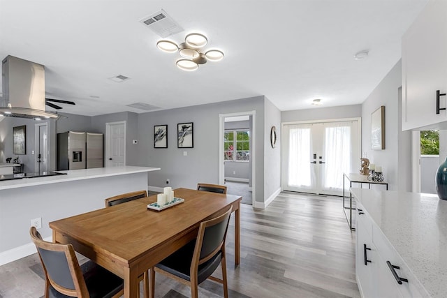 dining area with french doors, visible vents, baseboards, and light wood finished floors