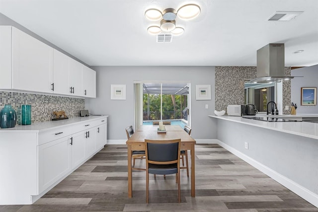 dining space featuring visible vents, baseboards, and wood finished floors