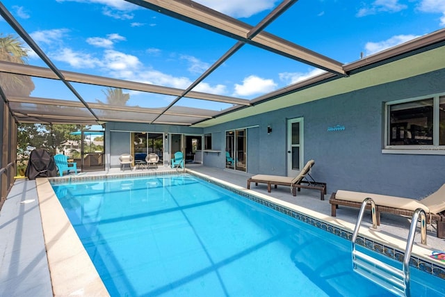 pool featuring glass enclosure and a patio area