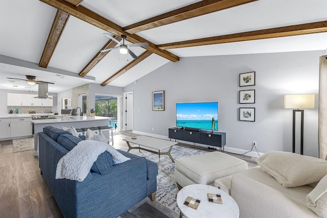 living room with vaulted ceiling with beams, light wood finished floors, ceiling fan, and baseboards