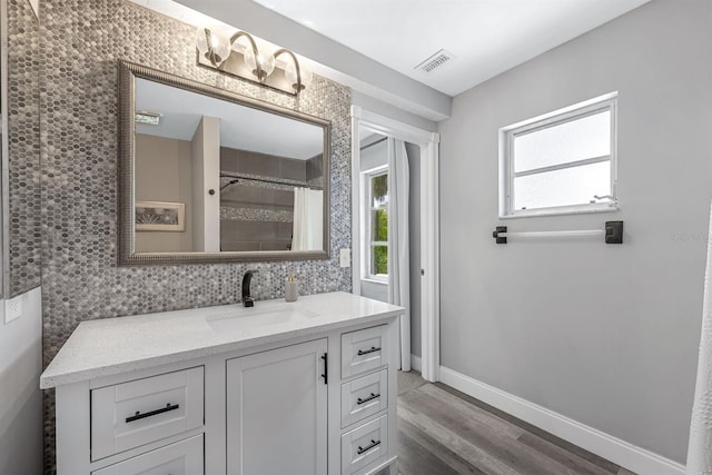 full bathroom with baseboards, a healthy amount of sunlight, visible vents, and vanity