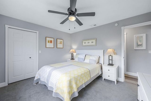 carpeted bedroom with a closet, visible vents, ceiling fan, and baseboards