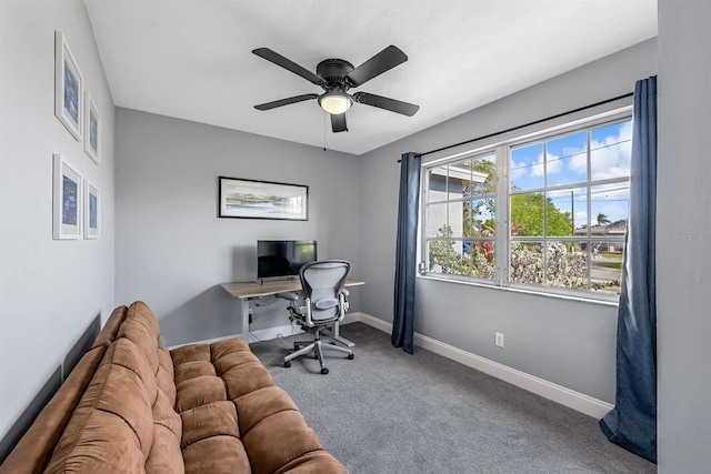 carpeted office featuring a ceiling fan and baseboards