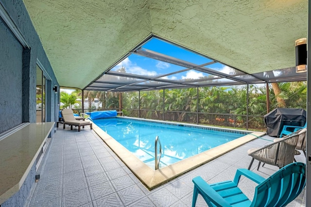 outdoor pool featuring a patio, a grill, and glass enclosure