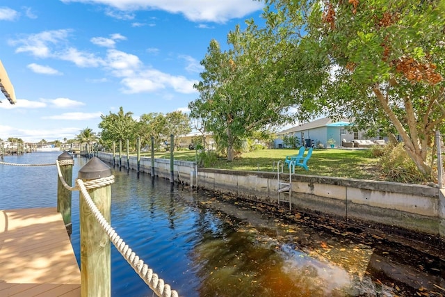 dock area with a water view and a lawn