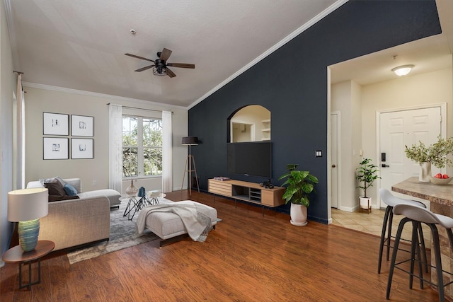 living room featuring vaulted ceiling, crown molding, and wood finished floors