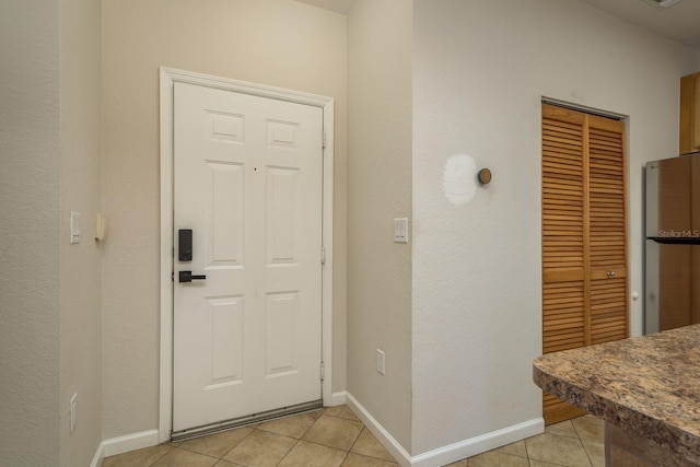 entryway with light tile patterned floors and baseboards