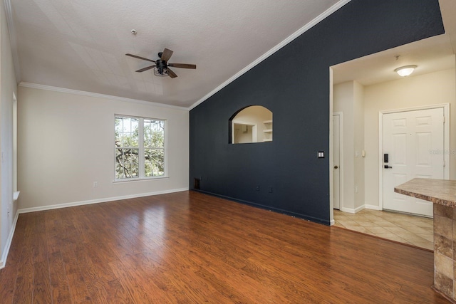 unfurnished room featuring lofted ceiling, ornamental molding, and wood finished floors