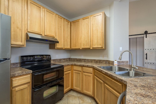 kitchen featuring a barn door, range with two ovens, freestanding refrigerator, under cabinet range hood, and a sink