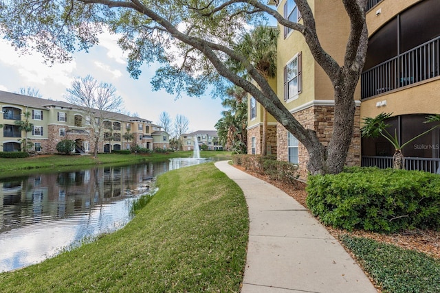 view of community with a residential view, a water view, and a yard