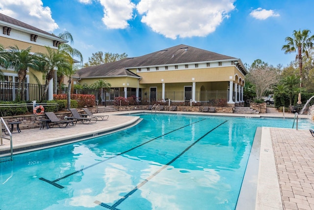 pool with a patio and fence