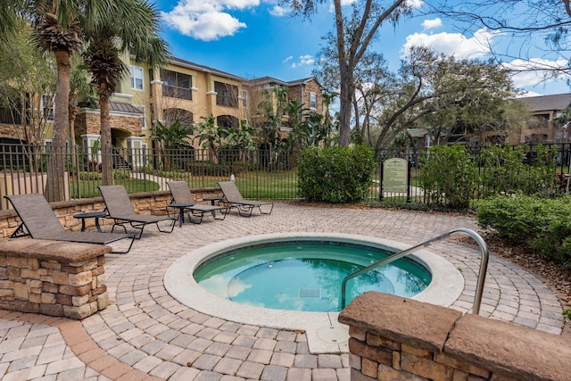 view of pool featuring a community hot tub, a patio area, and fence