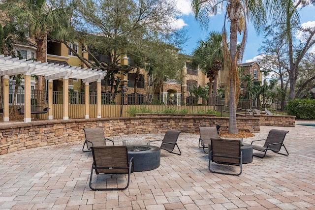 view of patio featuring a fire pit, fence, and a pergola