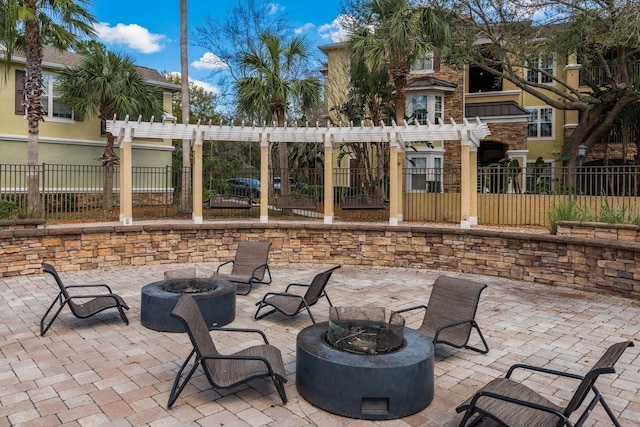 view of patio / terrace featuring a fire pit, fence, and a pergola