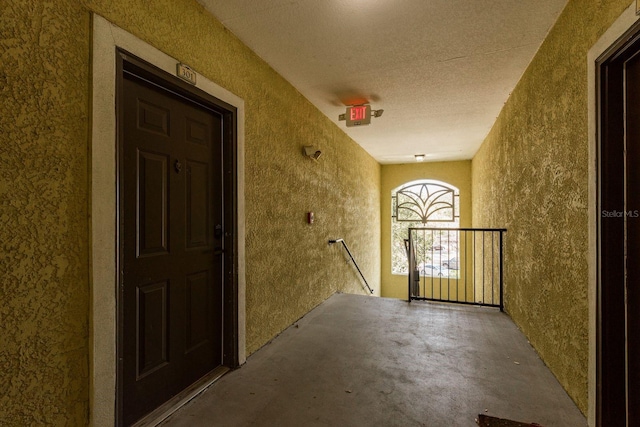 interior space featuring a textured wall and concrete floors