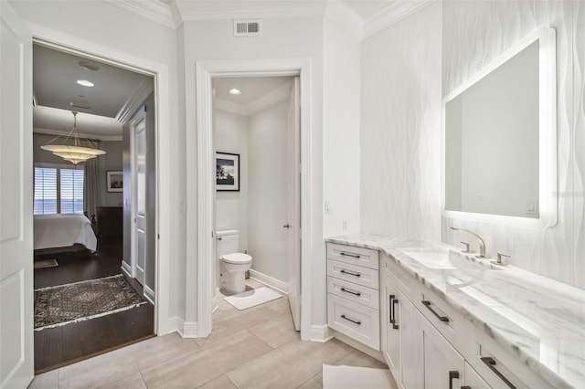 bathroom featuring ornamental molding, toilet, and ensuite bathroom