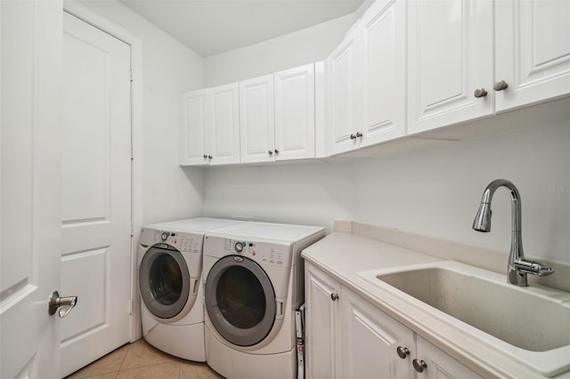 laundry room with light tile patterned floors, a sink, cabinet space, and washer and dryer