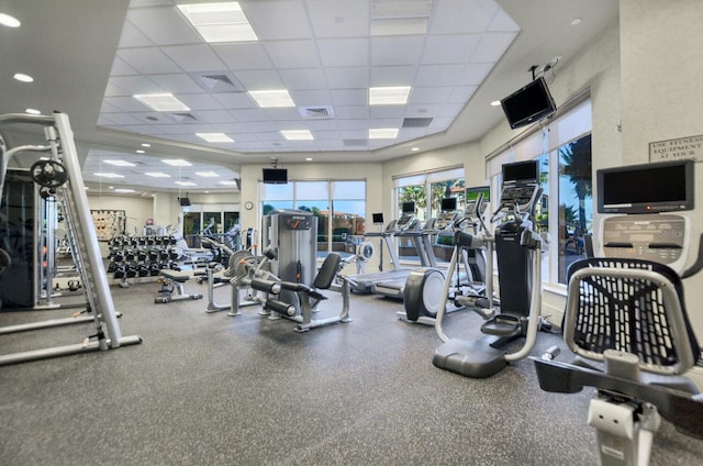 gym with a paneled ceiling and visible vents