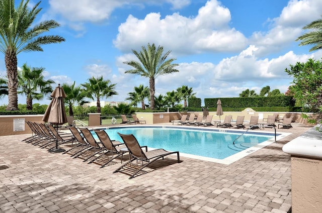 pool with a patio and fence