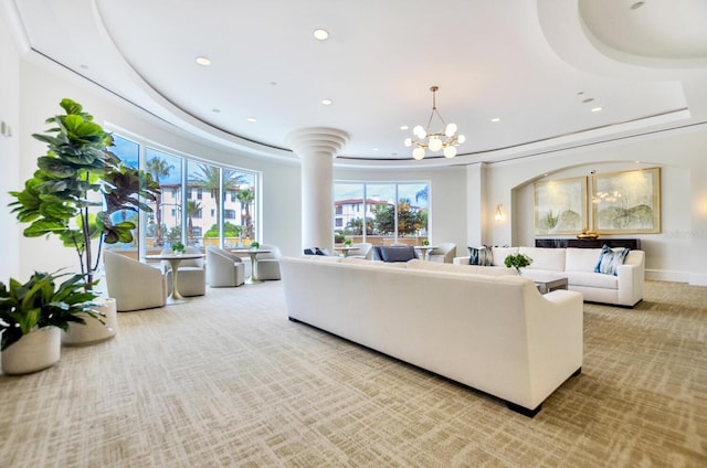 carpeted living area with baseboards, a raised ceiling, a notable chandelier, and recessed lighting