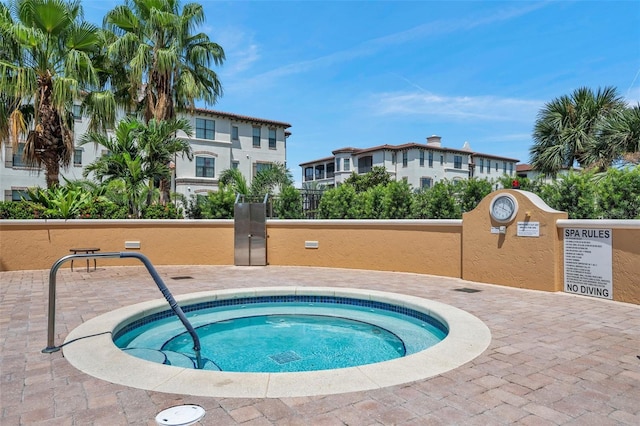 view of pool featuring fence and a community hot tub