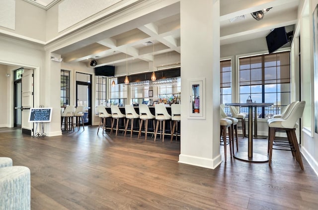 interior space featuring baseboards, coffered ceiling, and wood finished floors